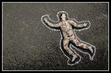 Soldier doll lying on ground with chalk outline.